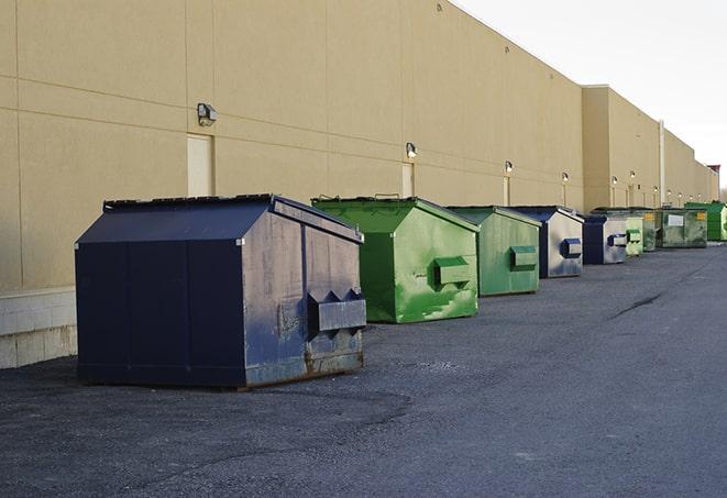 a row of yellow and blue dumpsters at a construction site in Colonie